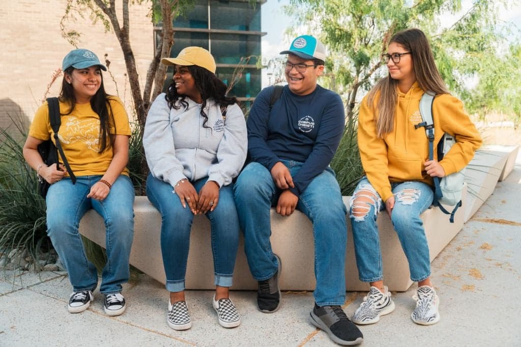 Four Del Mar students sit outside before class.